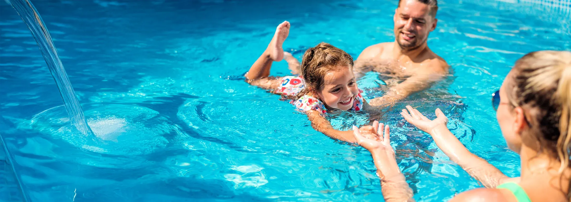 family swimming in a pool